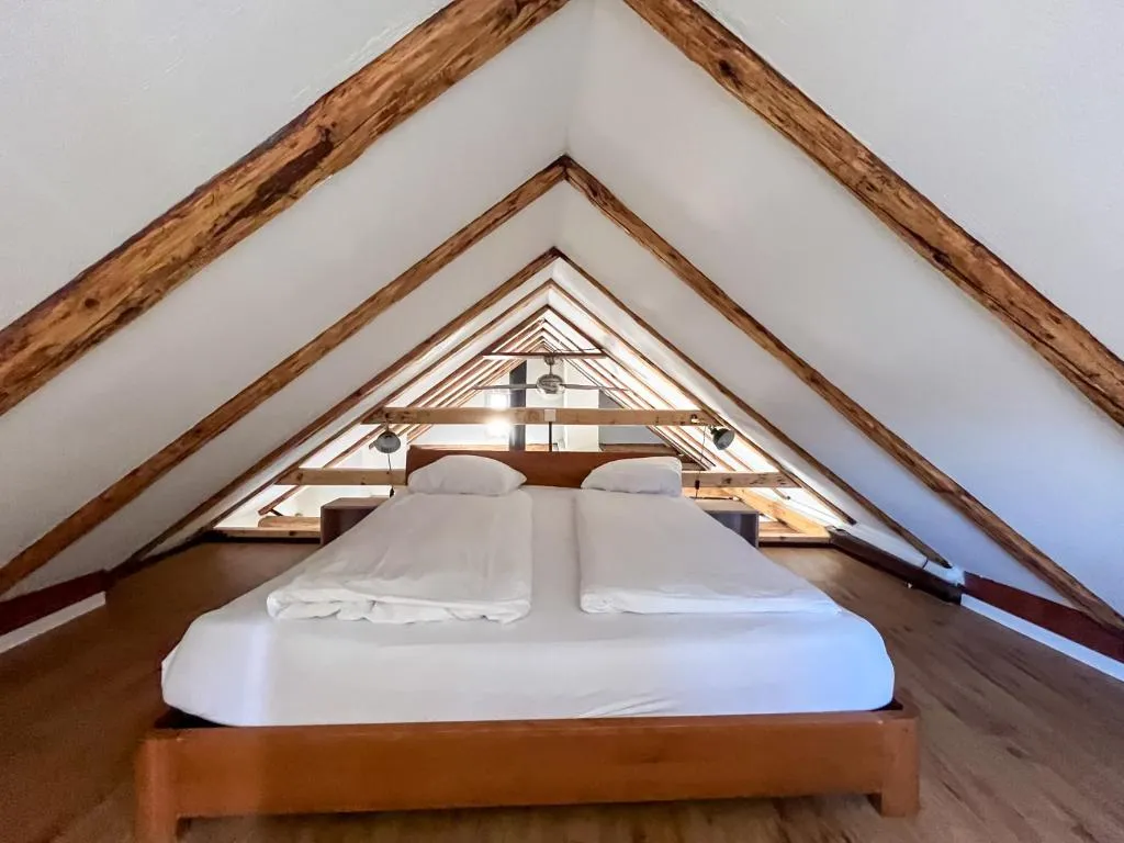 Dachzimmer mit freistehenden Holzbalken von 1450 im stattHotel Zürich