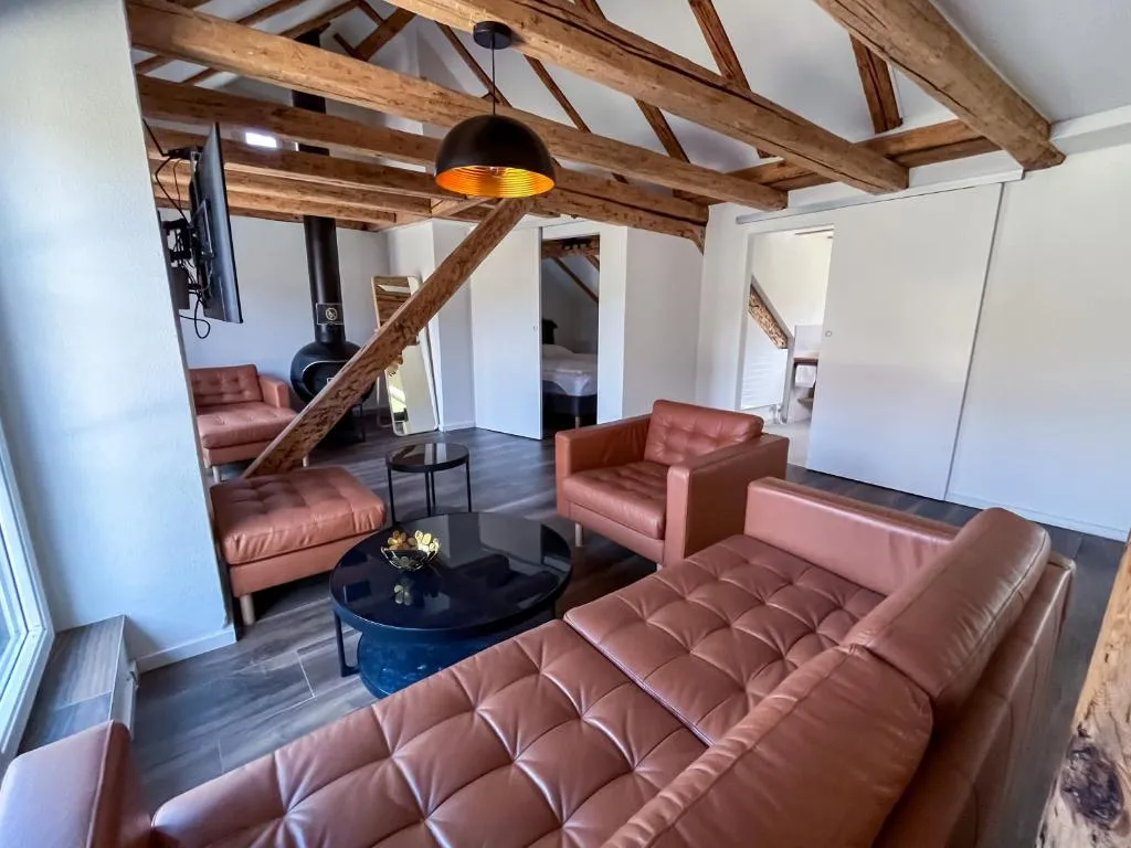 Suite im stattHotel Zürich mit Ledersofas unter historischen Holzbalken